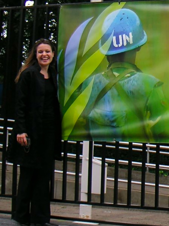 Melanie Nolte vor einem Plakat der UN-Friedenstruppen