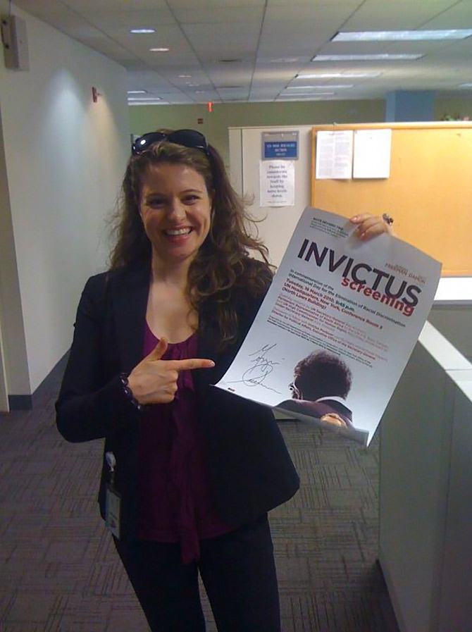Melanie Nolte zeigt auf ein Plakat zur Invictus-Filmvorführung